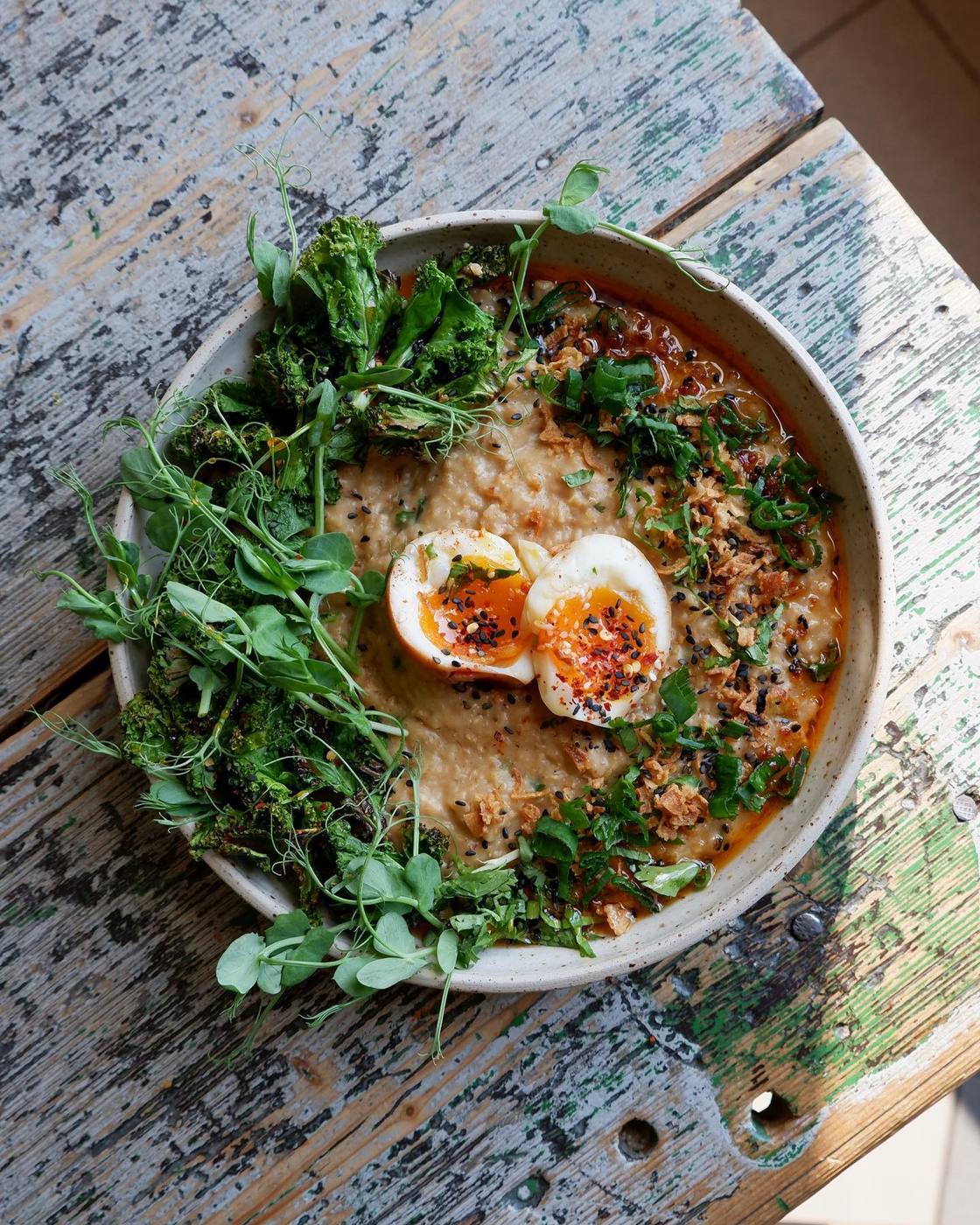 Savoury bowl topped with a soft-boiled egg and fresh greens