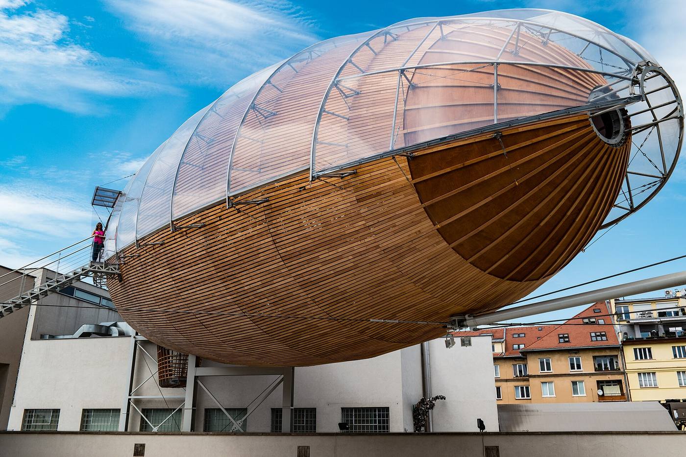 The Gulliver airship's timber hull resting on the roof of DOX against a blue sky