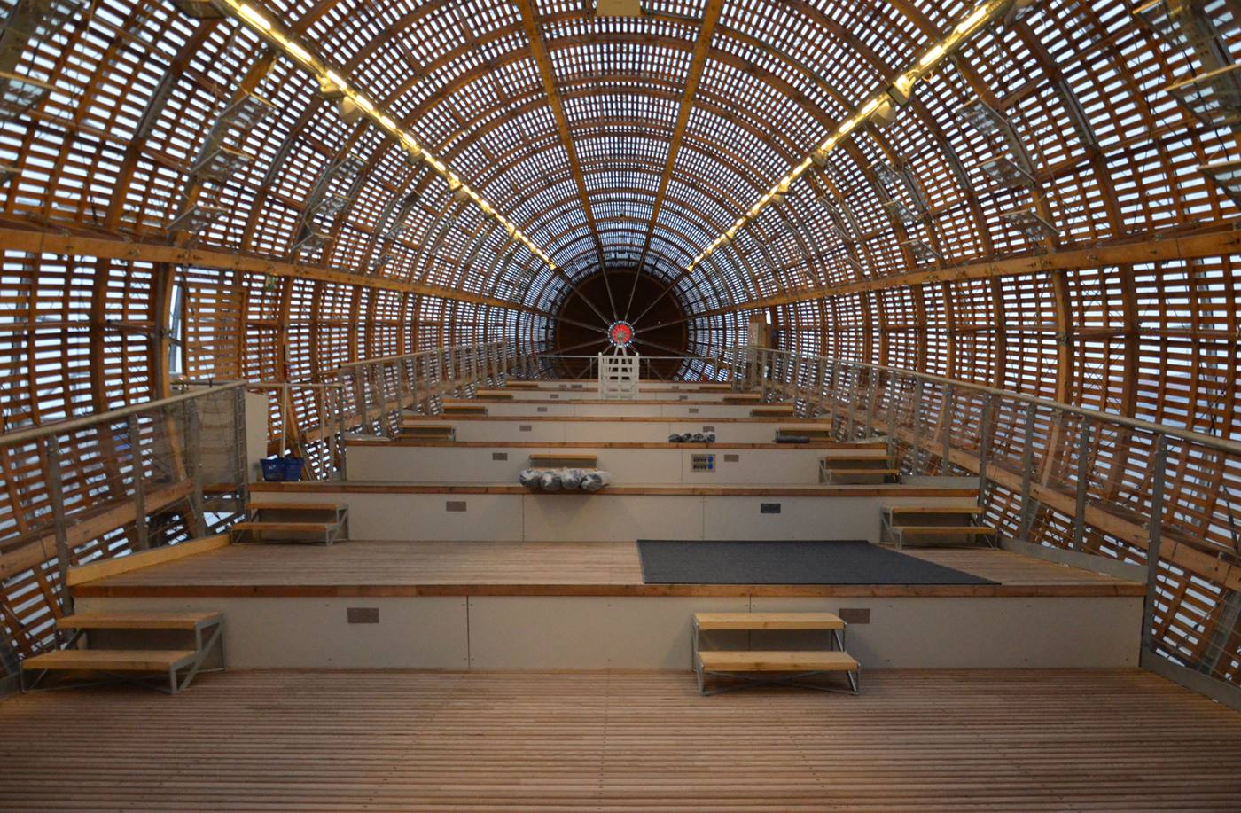 Inside the Gulliver airship: tiered wooden seating under a ribbed lattice ceiling