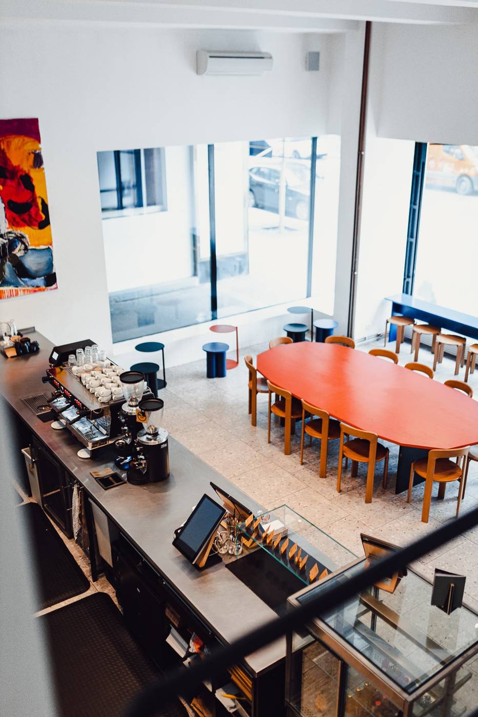 View from above of the bar and long orange communal table at EMA Na Florenci