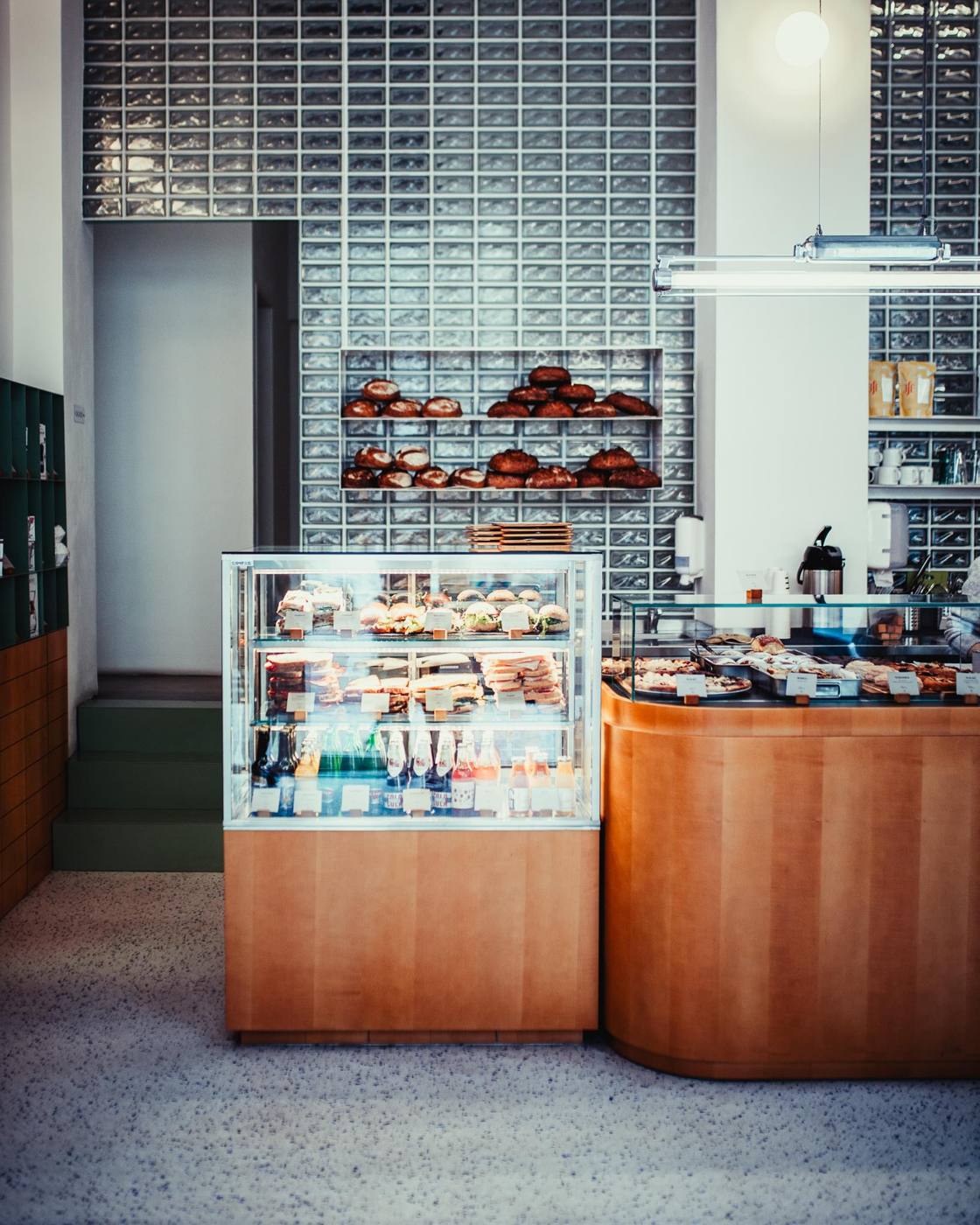Pastry display case and bread shelves at EMA Karlín