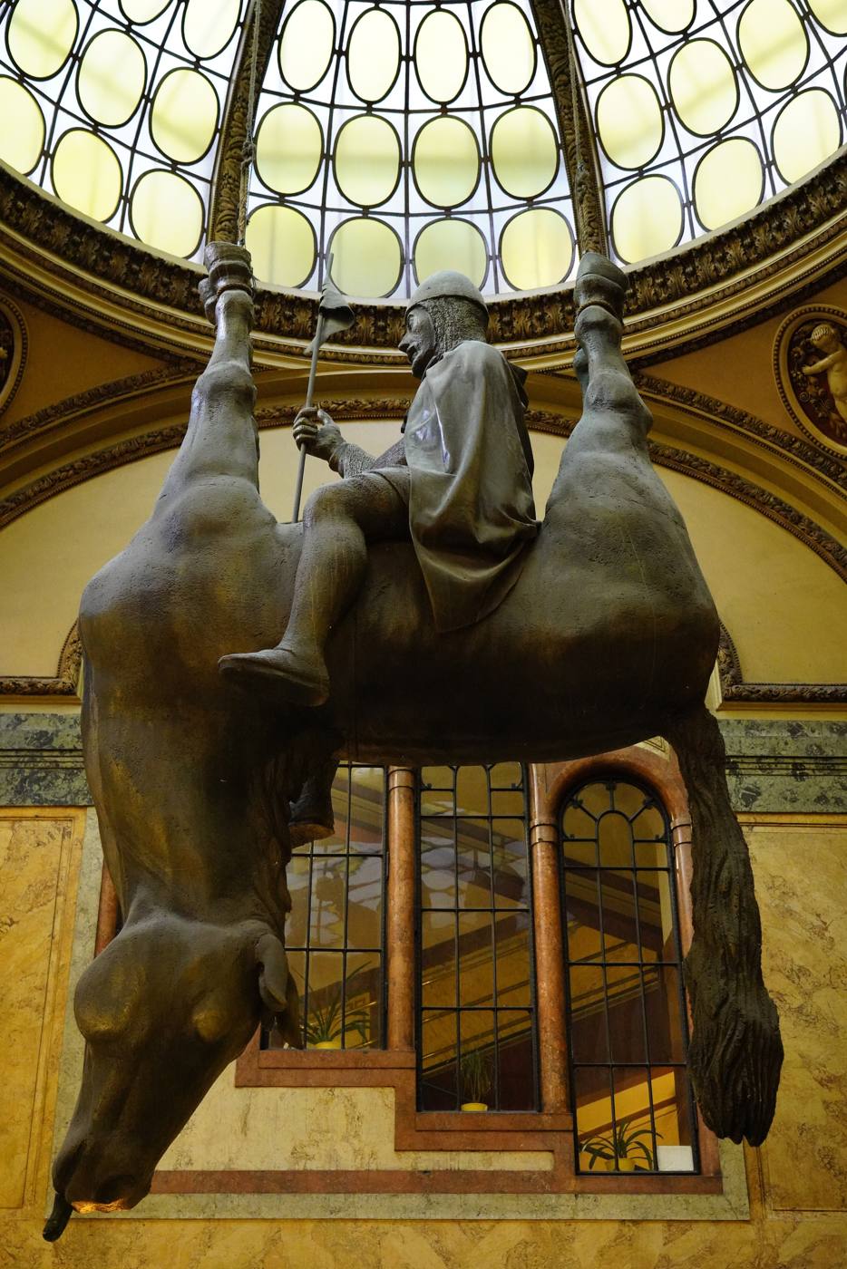 Close-up of the upside-down horse and its rider under the glass dome