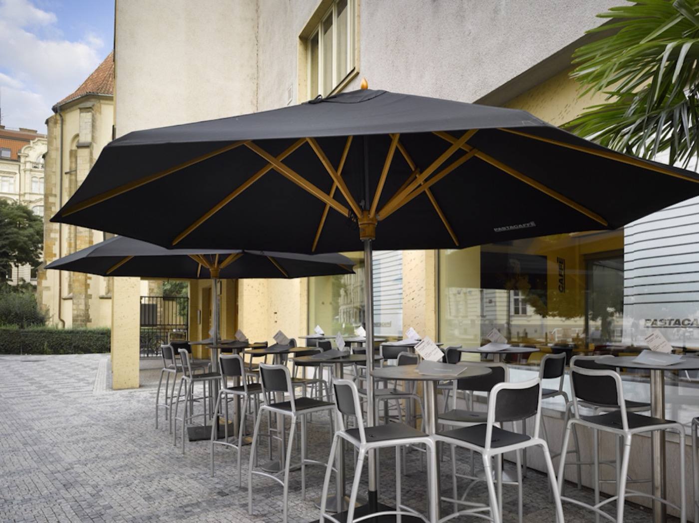 Outdoor terrace under large black parasols on Vězeňská street