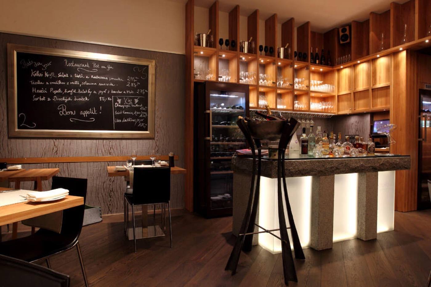 Illuminated granite bar, chalkboard menu and wine shelves at Pot au Feu
