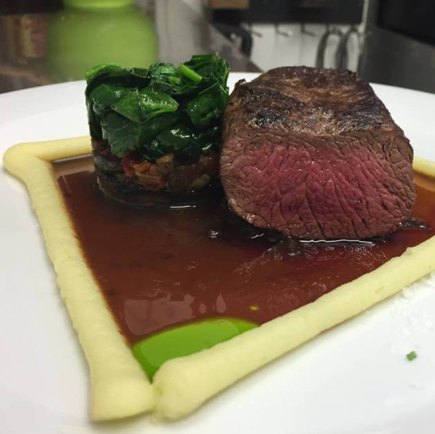 Pink beef fillet with spinach and a line of potato purée