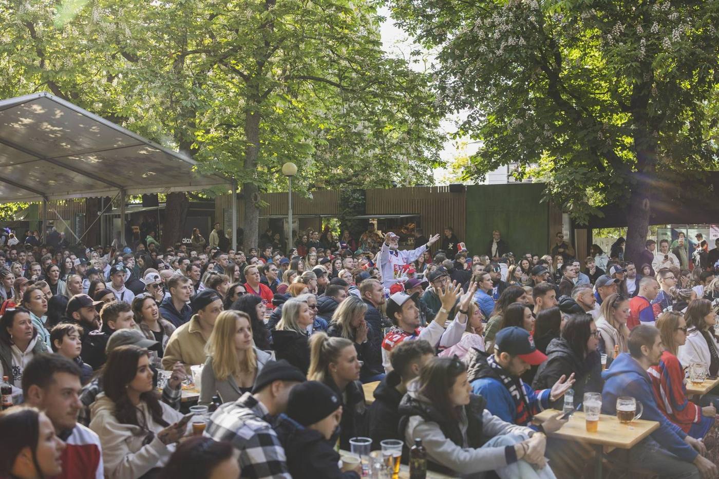 Packed tables in the Riegrovy sady beer garden under the trees