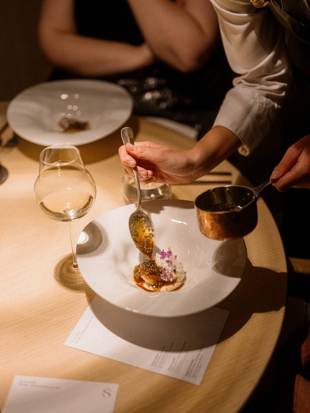 Sauce being poured tableside over a dish at Štangl