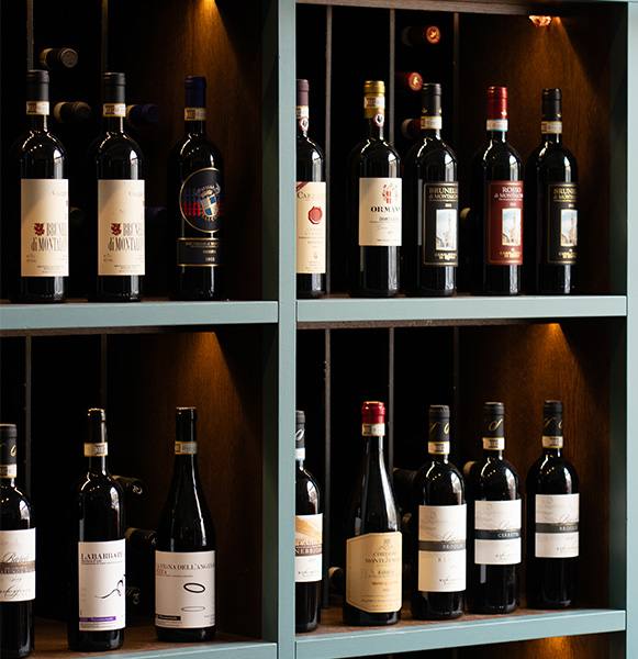 Backlit shelves of red wine bottles on Vinograf's wine wall