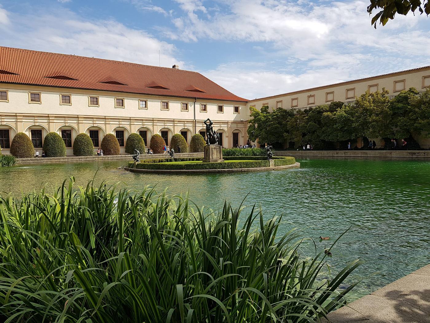 The pond in Wallenstein Garden with its fountain islet and the long palace wing beyond
