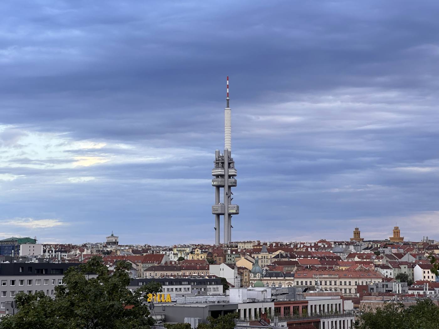 The Žižkov tower rising above the rooftops, seen from Vítkov hill